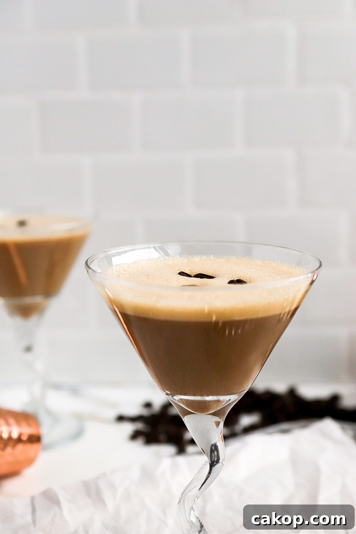 Close up shot of coffee cocktail in a glass with espresso beans on top.