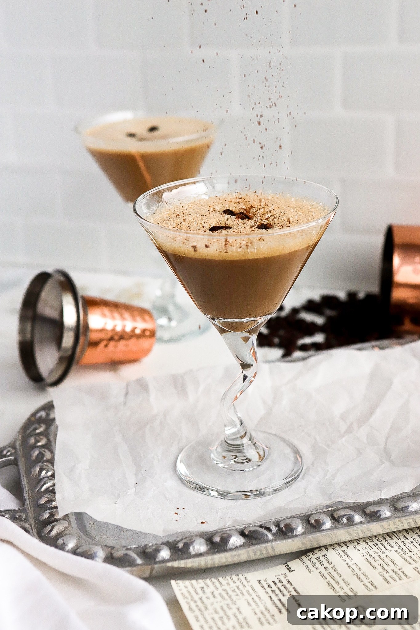 Front facing view of classic holiday cocktail with shaker cup in background.