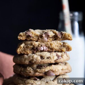 Chewy Milk Chocolate Chip Cookies Recipe for Perfect Cookies 11 A stack of chocolate chip cookies with the top one broken in half showing melted chocolate chip.
