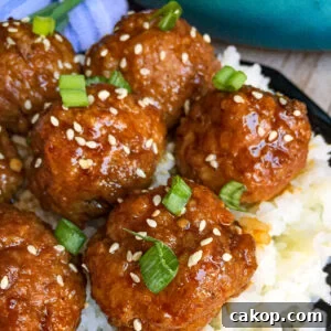 Sticky Asian Glazed Meatballs Recipe: Sweet-Savory Sauce Guide 4 Asian Glazed Meatballs with white rice, sesame seeds, and green onions sprinkled on top for a garnish