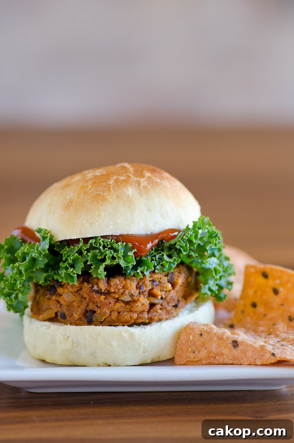 sweet potato and black bean burger on a bun with quinoa chips