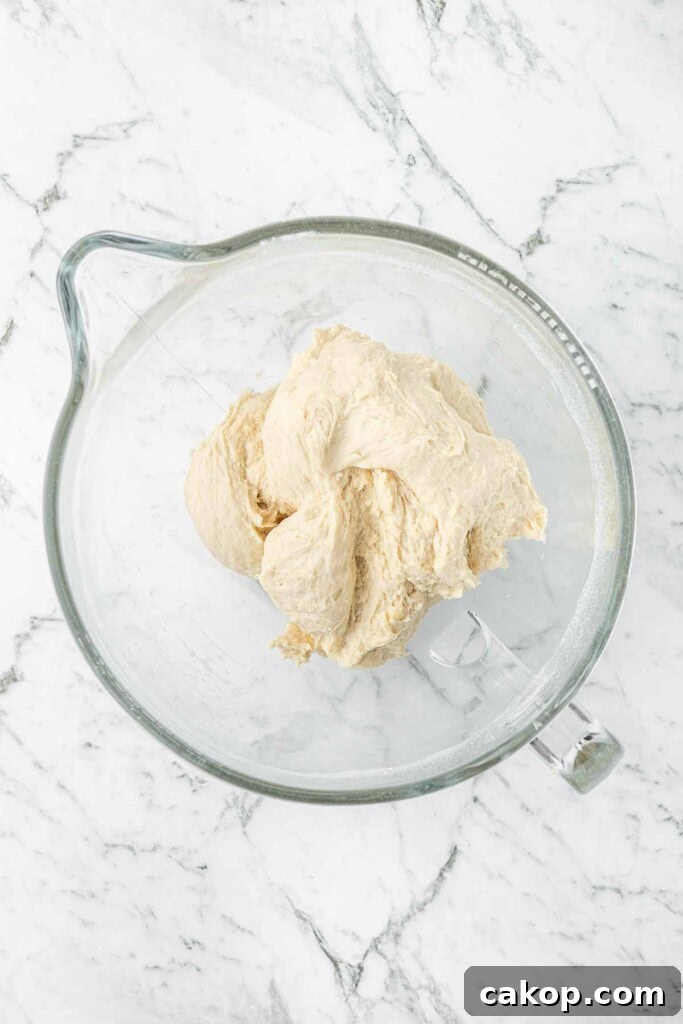 Mixing up the pizza dough in a glass bowl.