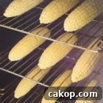 Three racks of corn inside a smoker