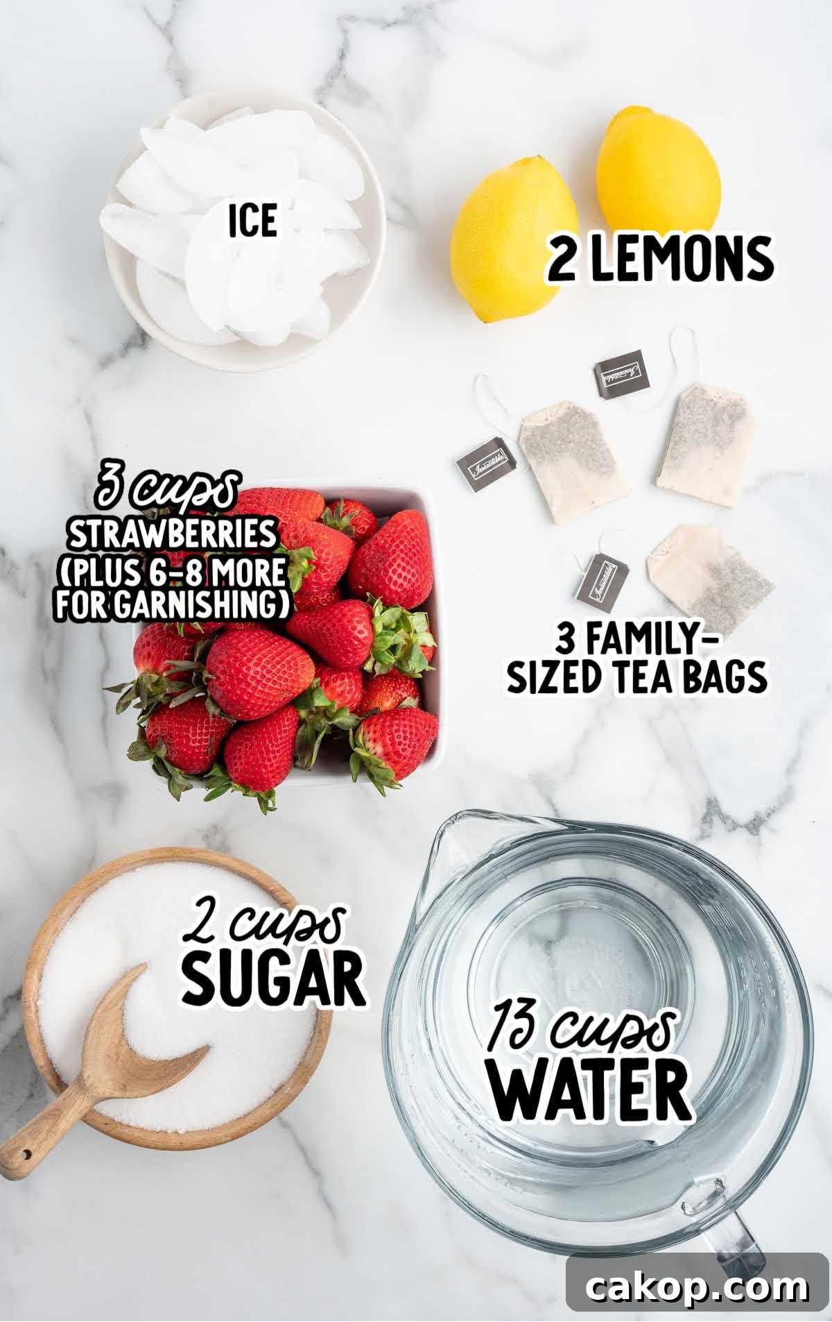 Flat lay of sweet tea ingredients including lemons, strawberries, sugar, tea bags, ice, and a pitcher of water.