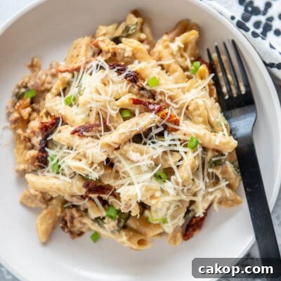 sausage pasta bake on a white plate with fork