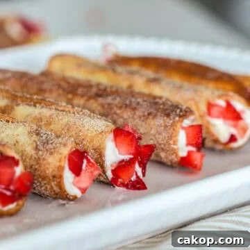 Cheesecake cigars on plate with strawberries.