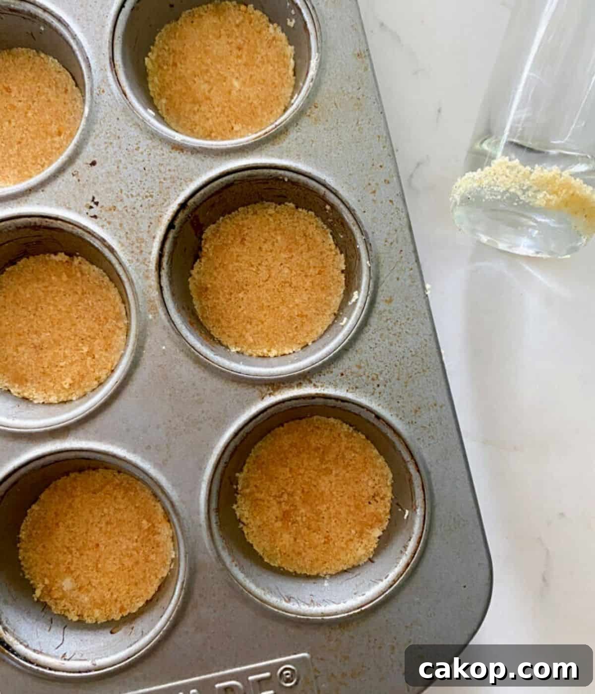 Mini Cheesecakes with Cookie Crust — Irresistible Bite-Sized Treats 4 cookie crust in a muffin pan for mini cheesecakes.