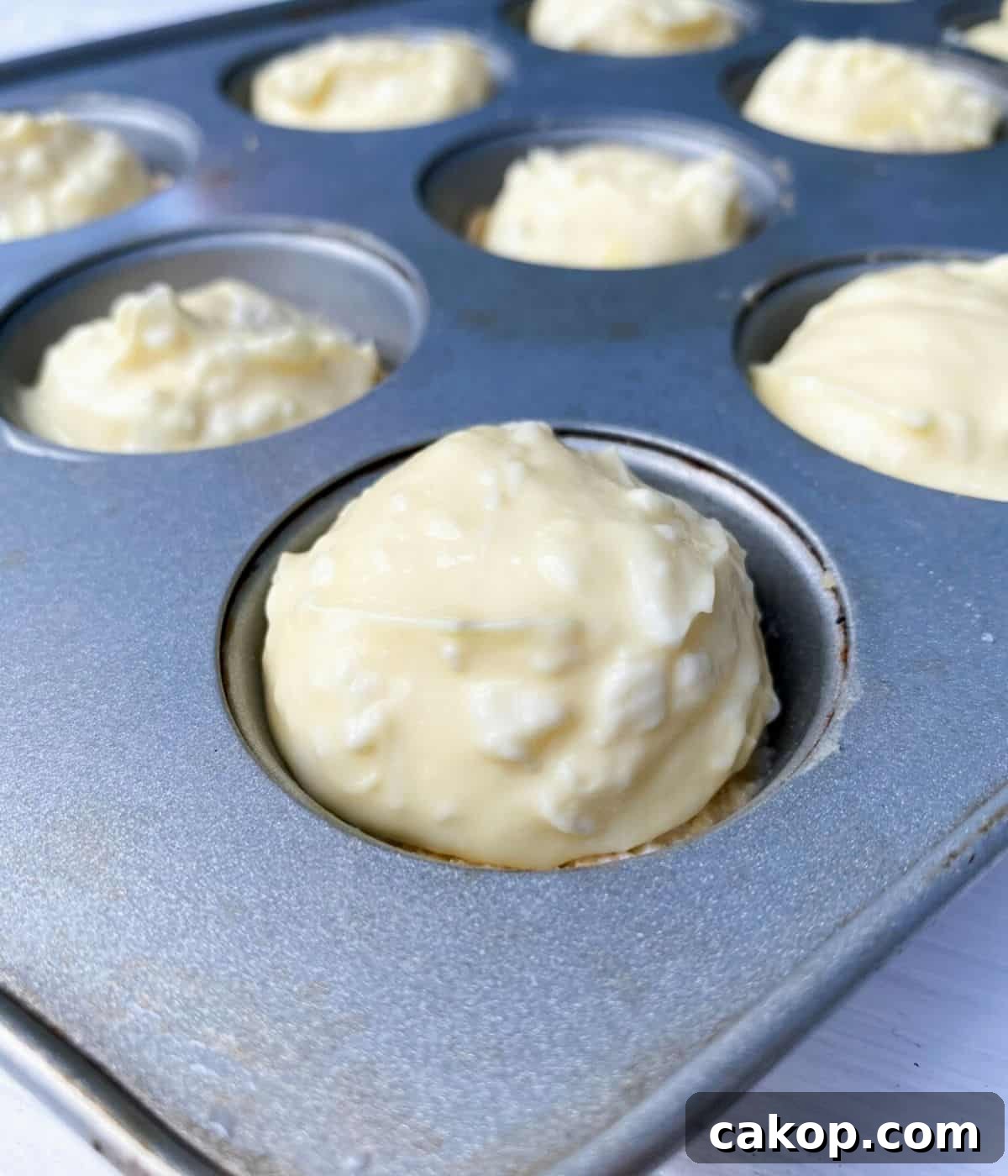 Mini Cheesecakes with Cookie Crust — Irresistible Bite-Sized Treats 5 Cheesecake batter in mini muffin tin.