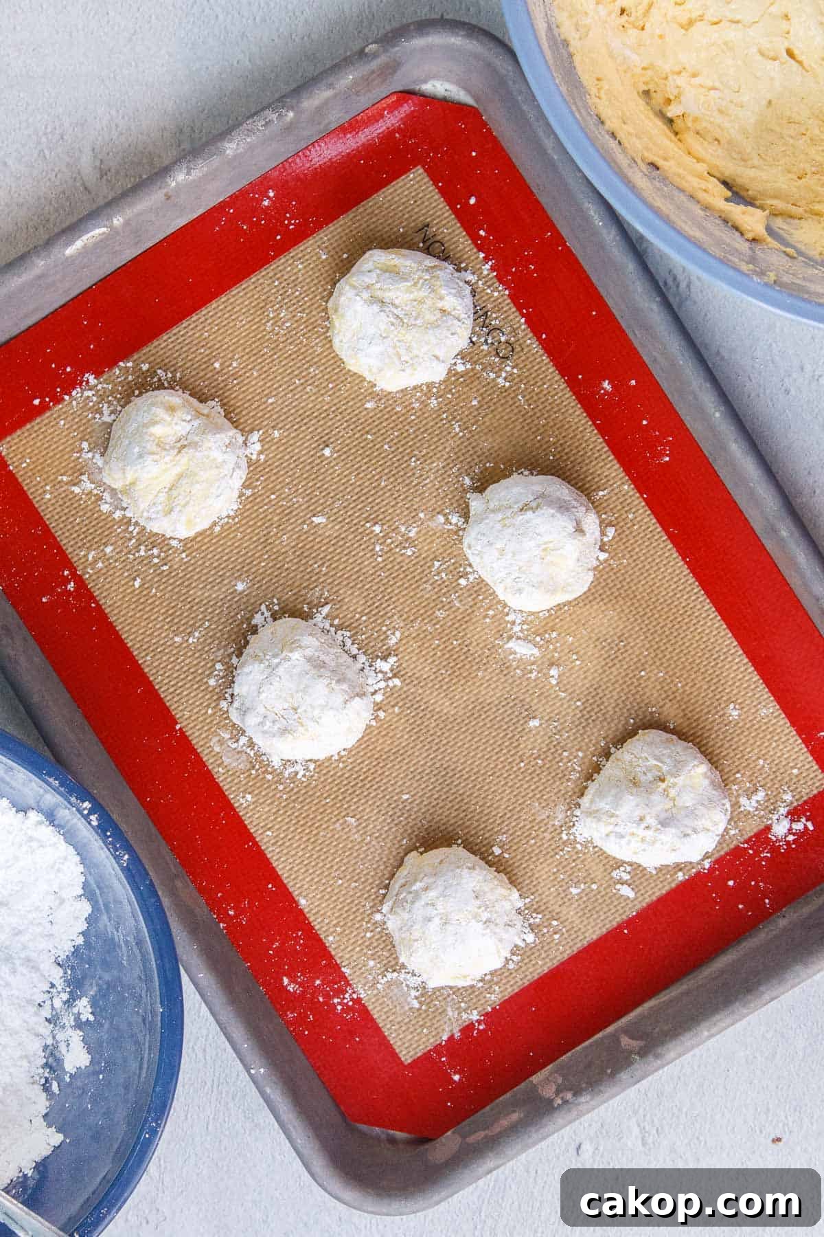 Unbaked Lemon Cool Whip Cookie dough balls on a prepared baking sheet