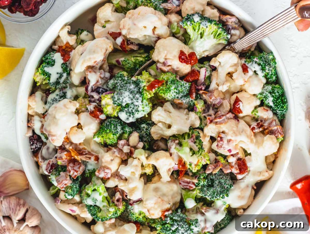 Step 4 Tossing healthy broccoli cauliflower salad with creamy Greek yogurt dressing before chilling.