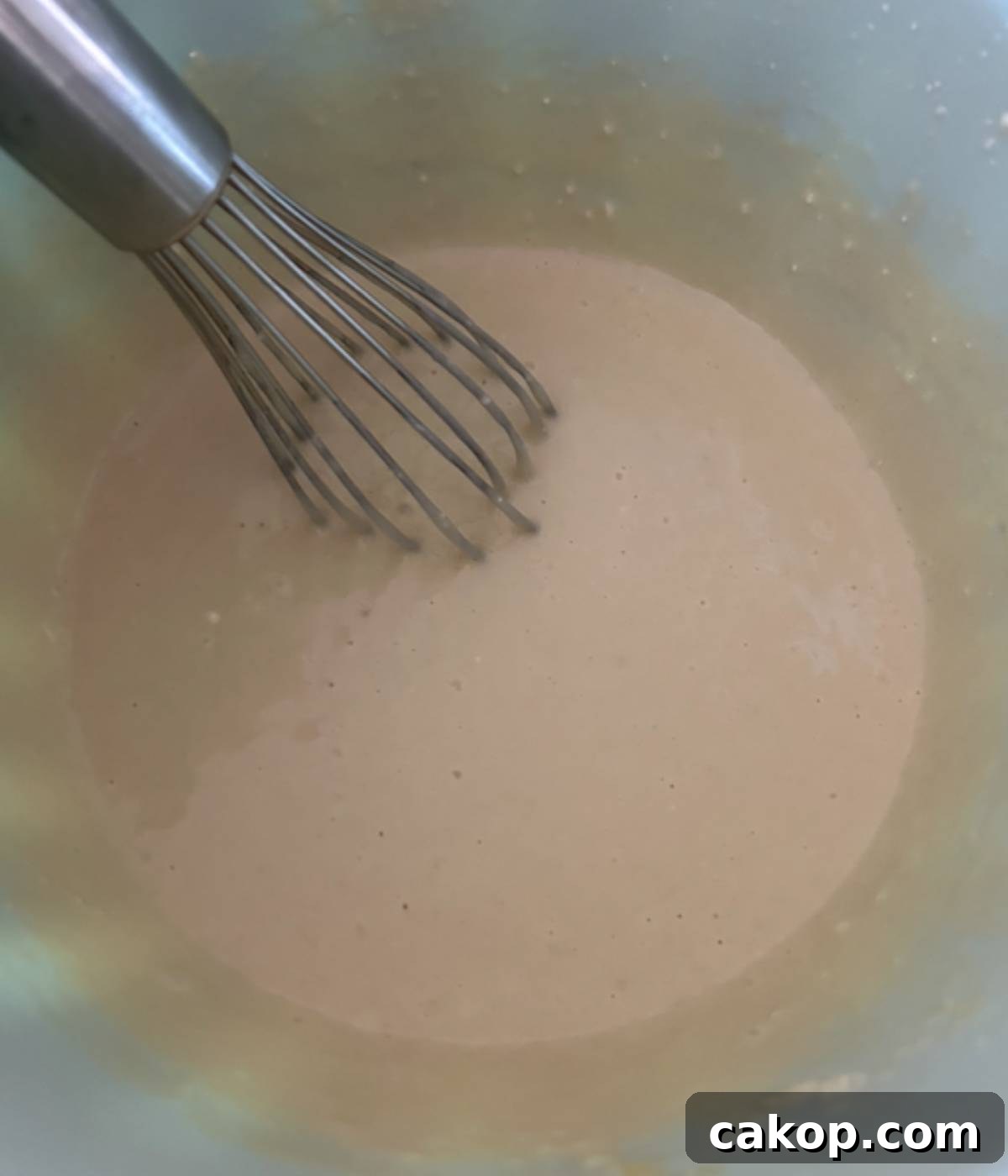 Sheet-Pan Pancakes from Mix (Oven-Baked) 6 Whisking pancake mix in blue bowl.
