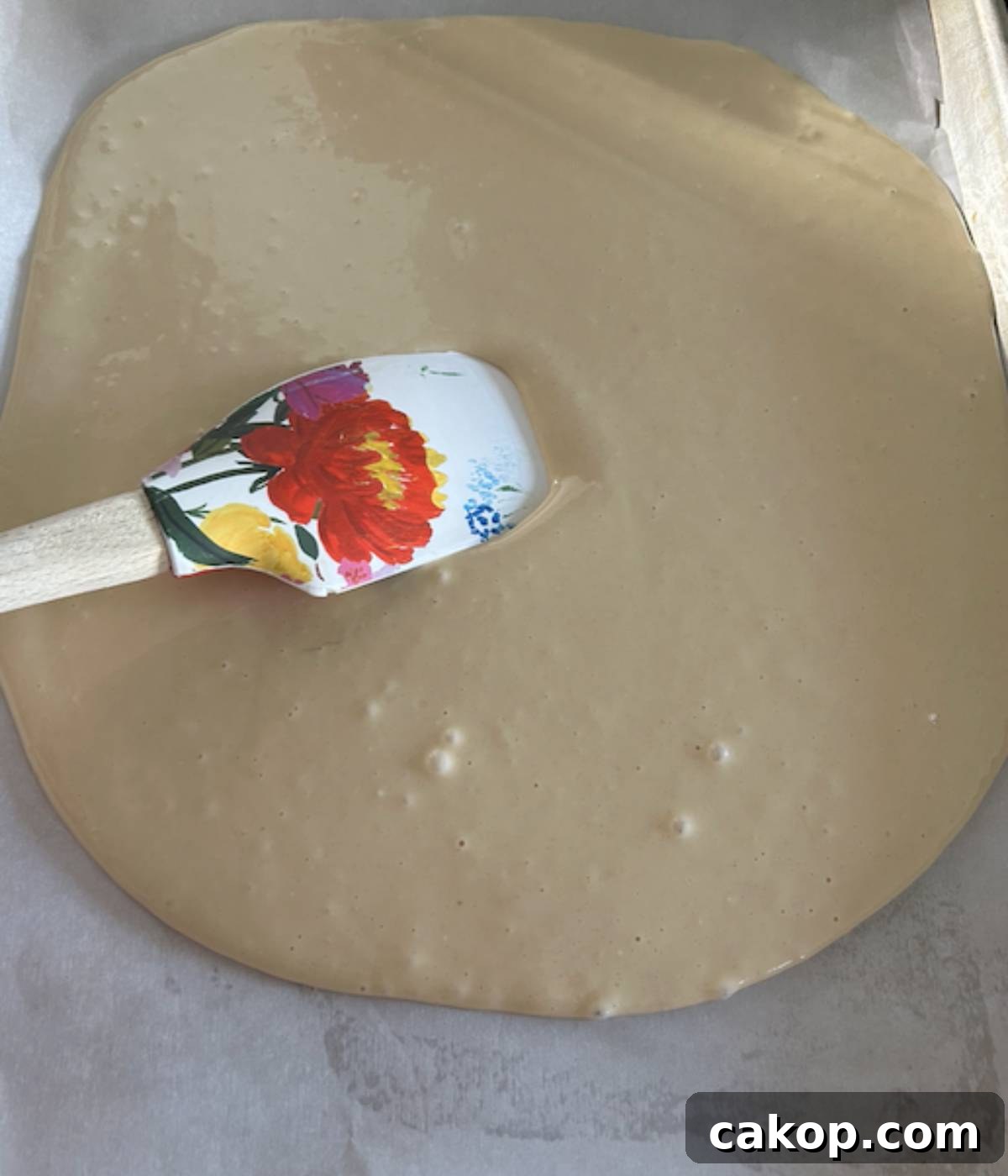 Sheet-Pan Pancakes from Mix (Oven-Baked) 7 Spatula spreading bisquick pancake mix in cookie sheet.