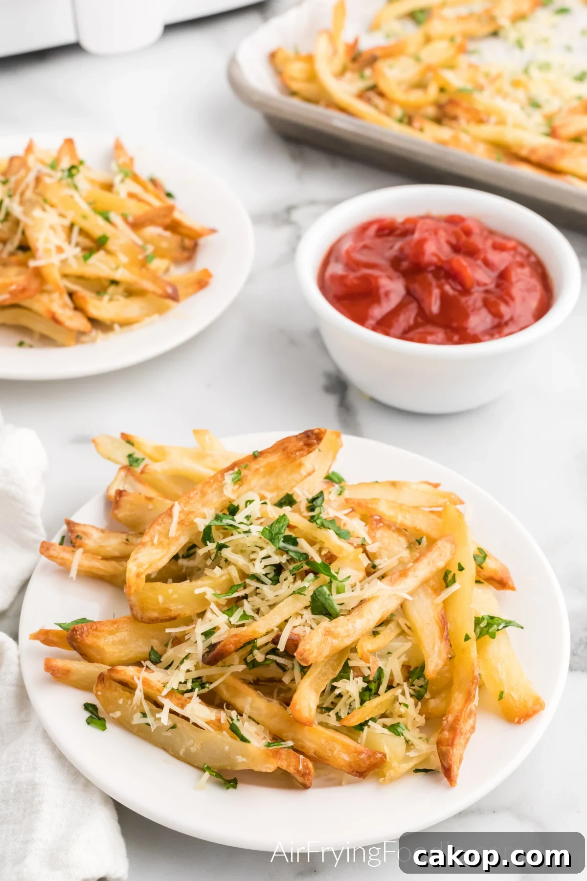 Crispy Air Fryer Truffle Fries Recipe 2 Air fried truffle fried on a white plate with a side of ketchup.