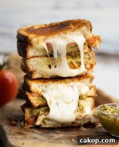 4 sandwich halves stacked on each other on wooden board