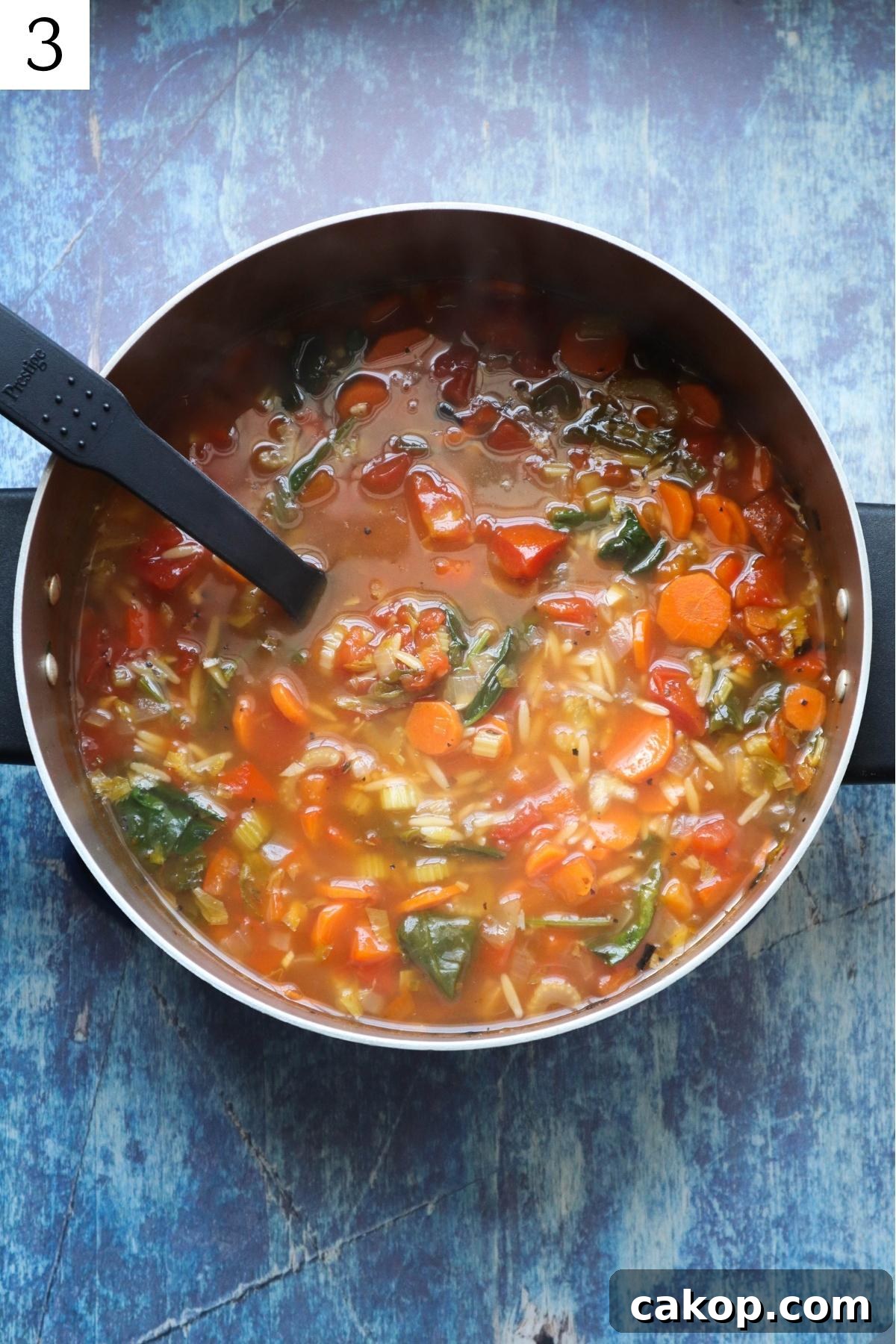 pot with broth and vegetables to make orzo vegetable soup.