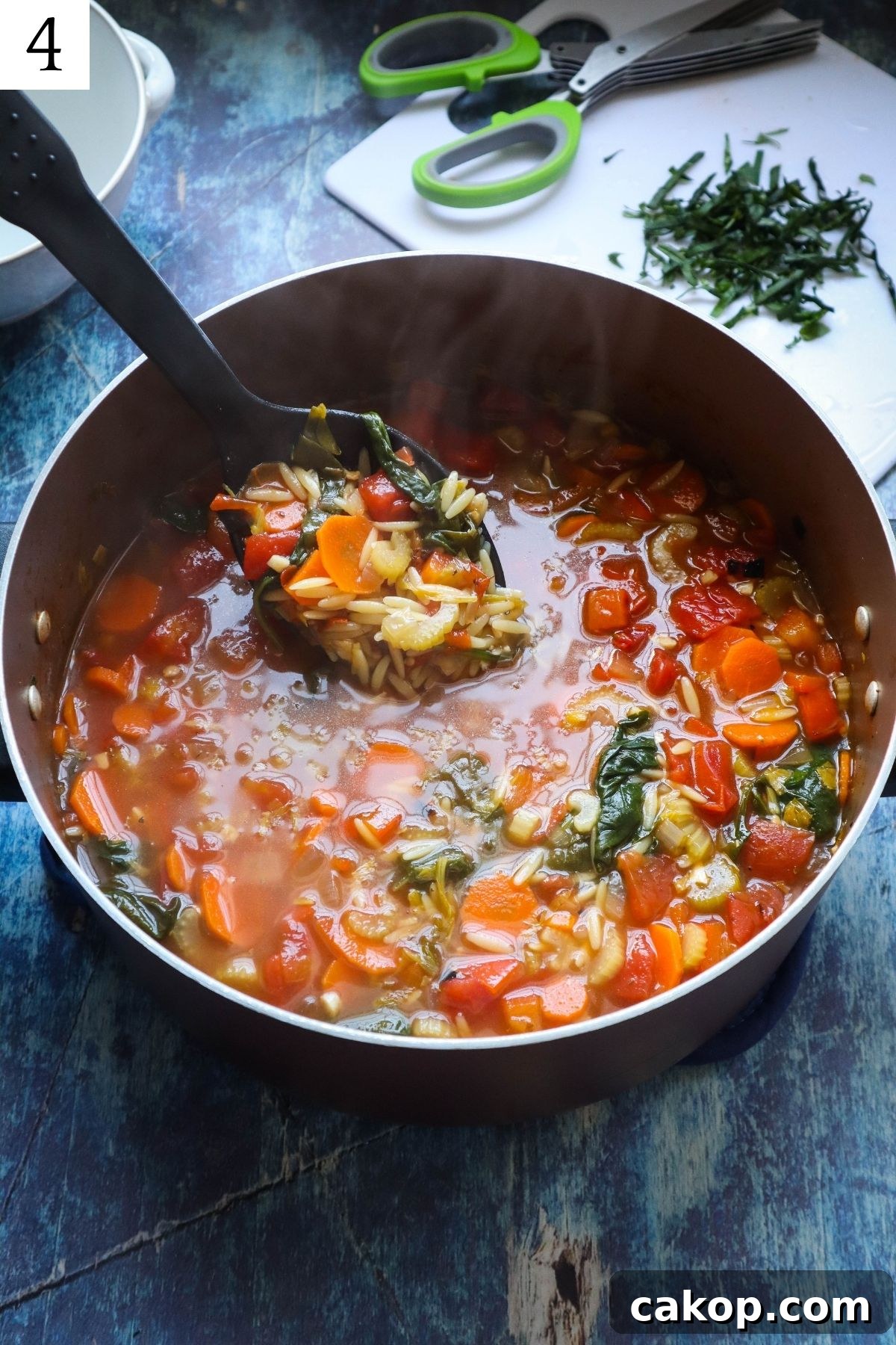 pot with orzo vegetable soup with spoon scooping soup. 