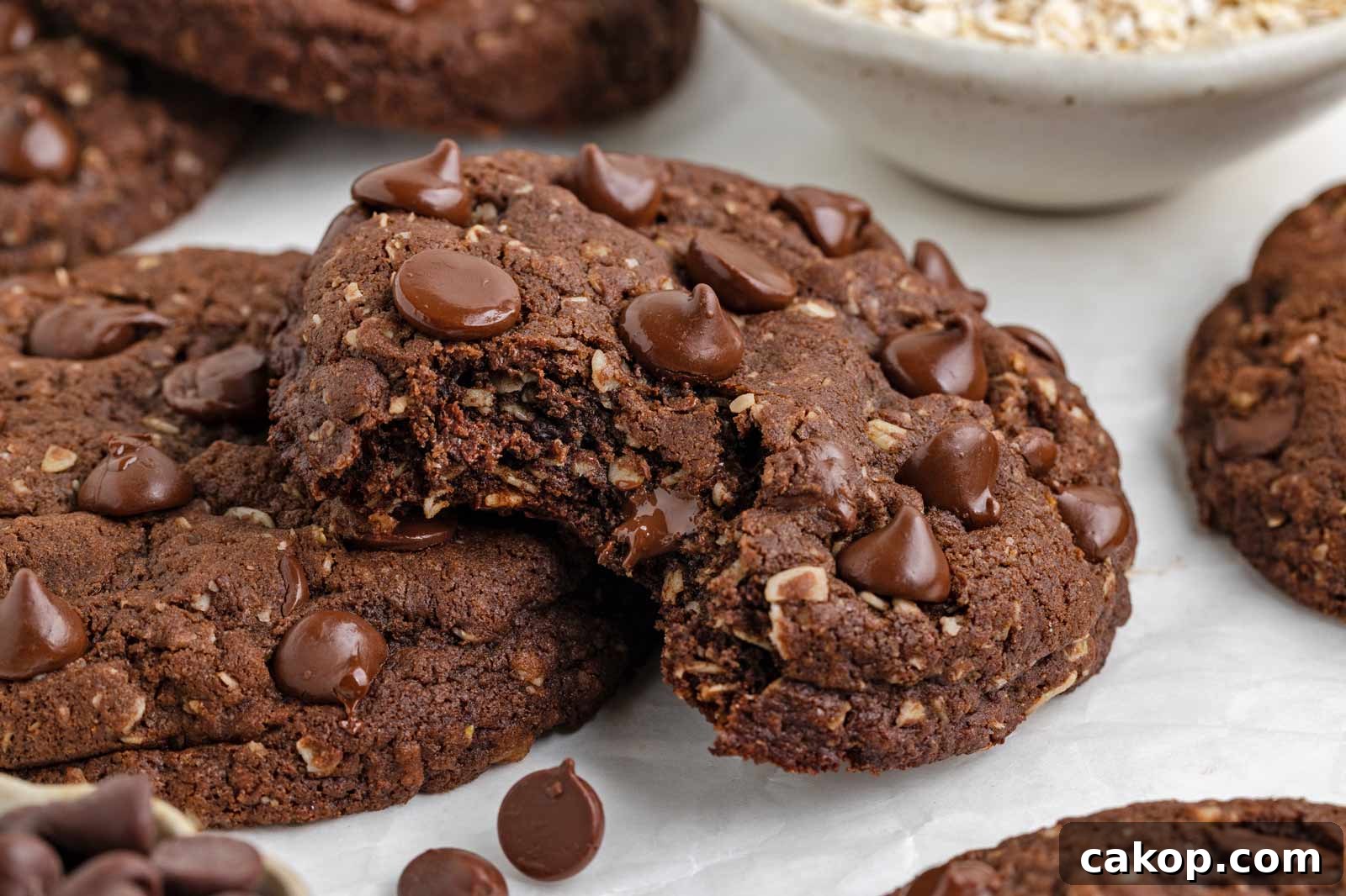 bit into cocoa oatmeal cookie on a white piece of parchment paper