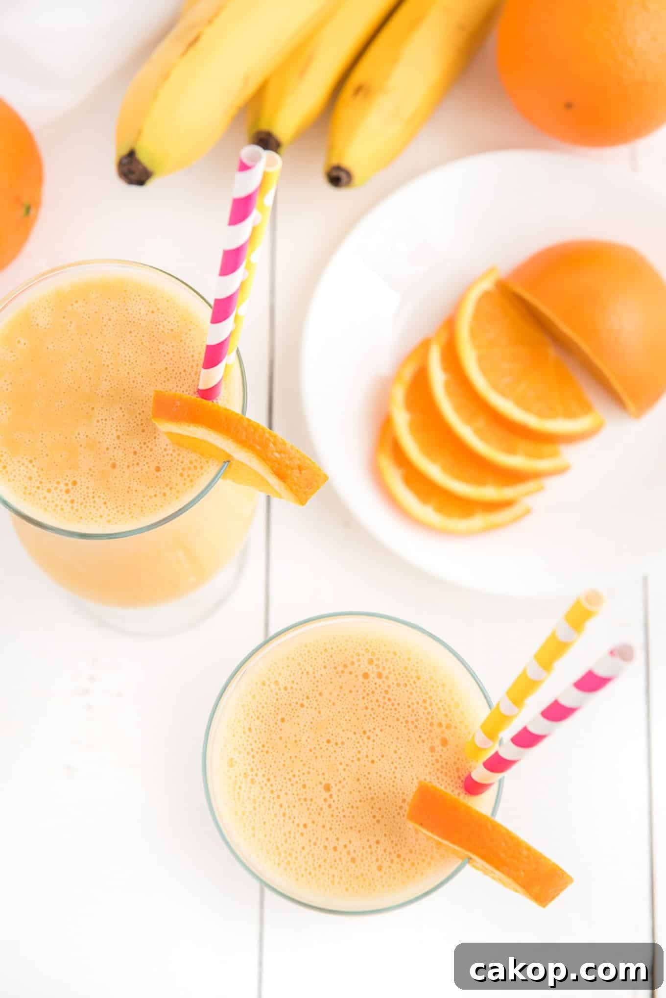 Creamy Orange Smoothie Recipe for Fresh, Zesty Mornings 5 Above shot of two orange smoothie drinks surrounded by the key ingredients.