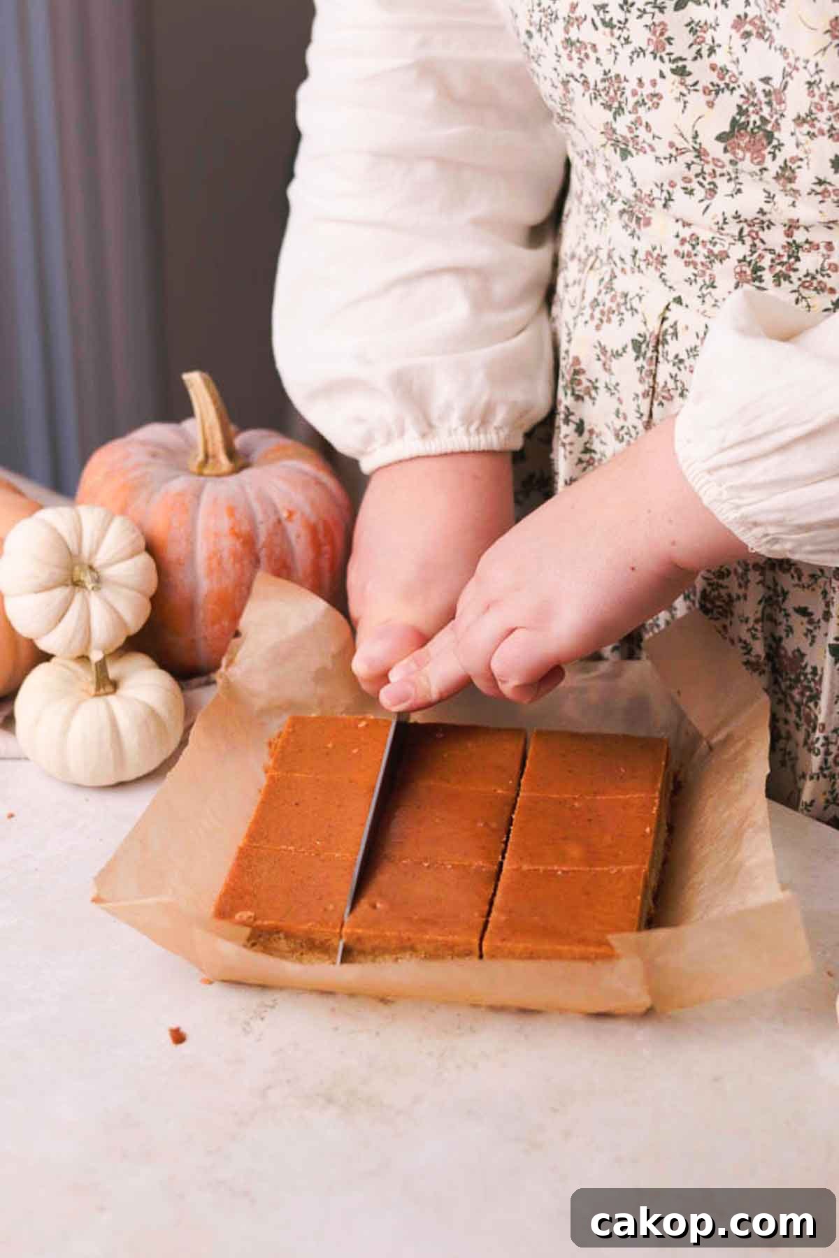Creamy Pumpkin Pie Bars with Gingersnap Crust 14 cutting bars into squares with a knife