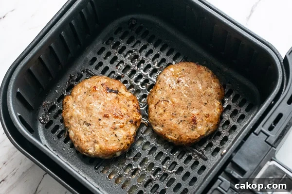 2 cooked turkey patties in air fryer basket