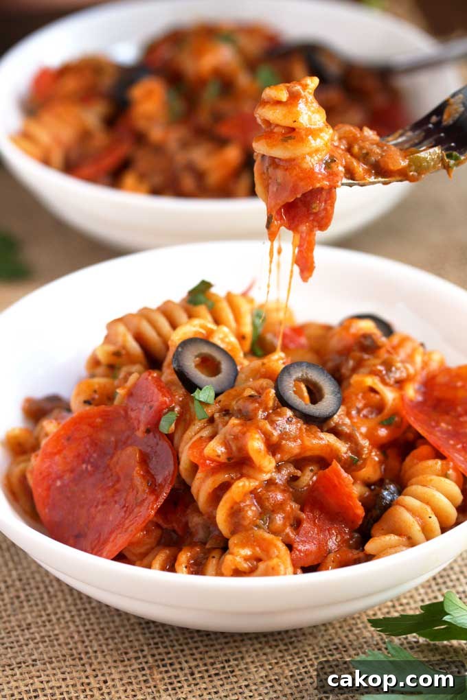 Fork picking up a cheesy noodle from a bowl