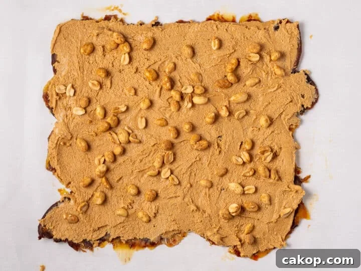 High-Protein Snickers Date Bark Recipe for Satisfying Snacks 13 Chopped peanuts scattered over the peanut butter layer