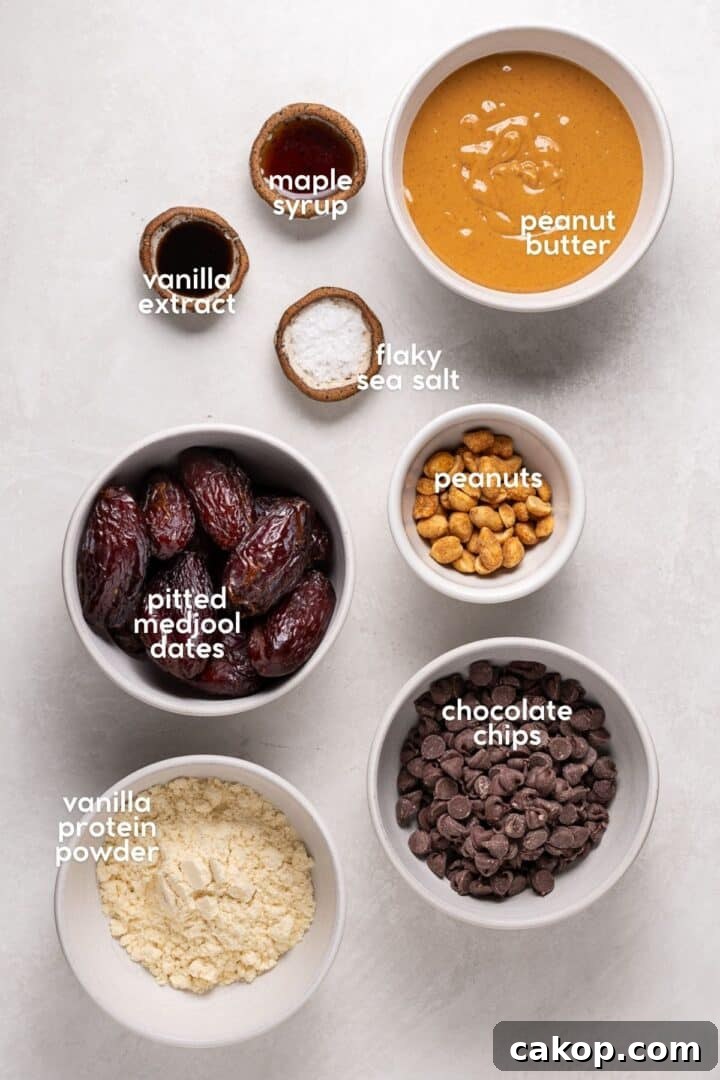 High-Protein Snickers Date Bark Recipe for Satisfying Snacks 5 Labeled ingredients for a date bark recipe including dates, peanut butter, chocolate chips, peanuts, maple syrup, vanilla, and flaky salt