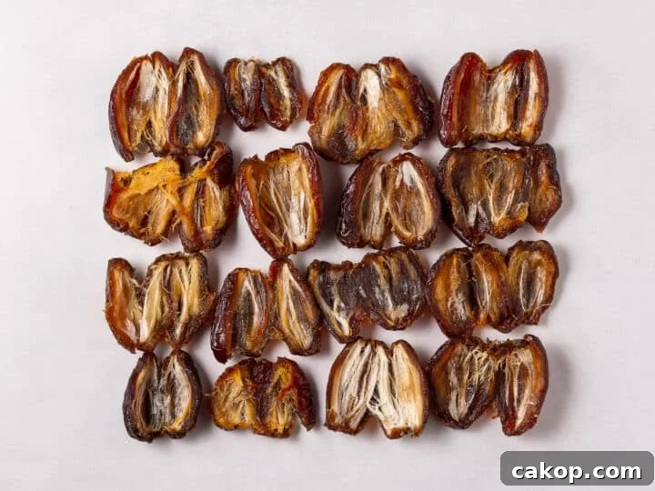 High-Protein Snickers Date Bark Recipe for Satisfying Snacks 7 Pitted dates arranged in rows on parchment paper