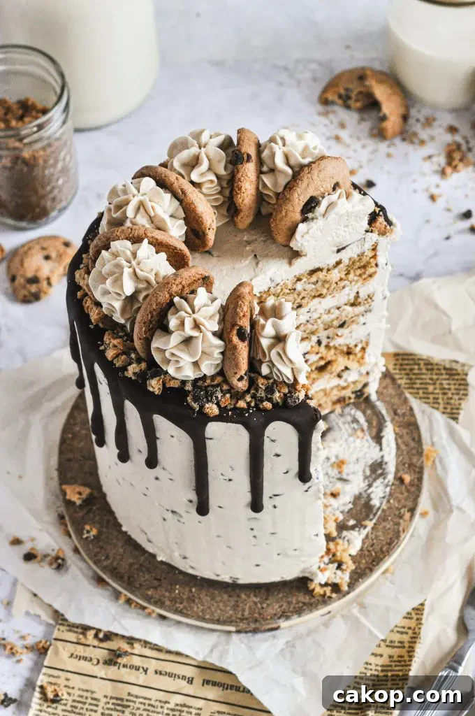 A chocolate chip cookie cake topped with cookie swirls and a large slice removed.