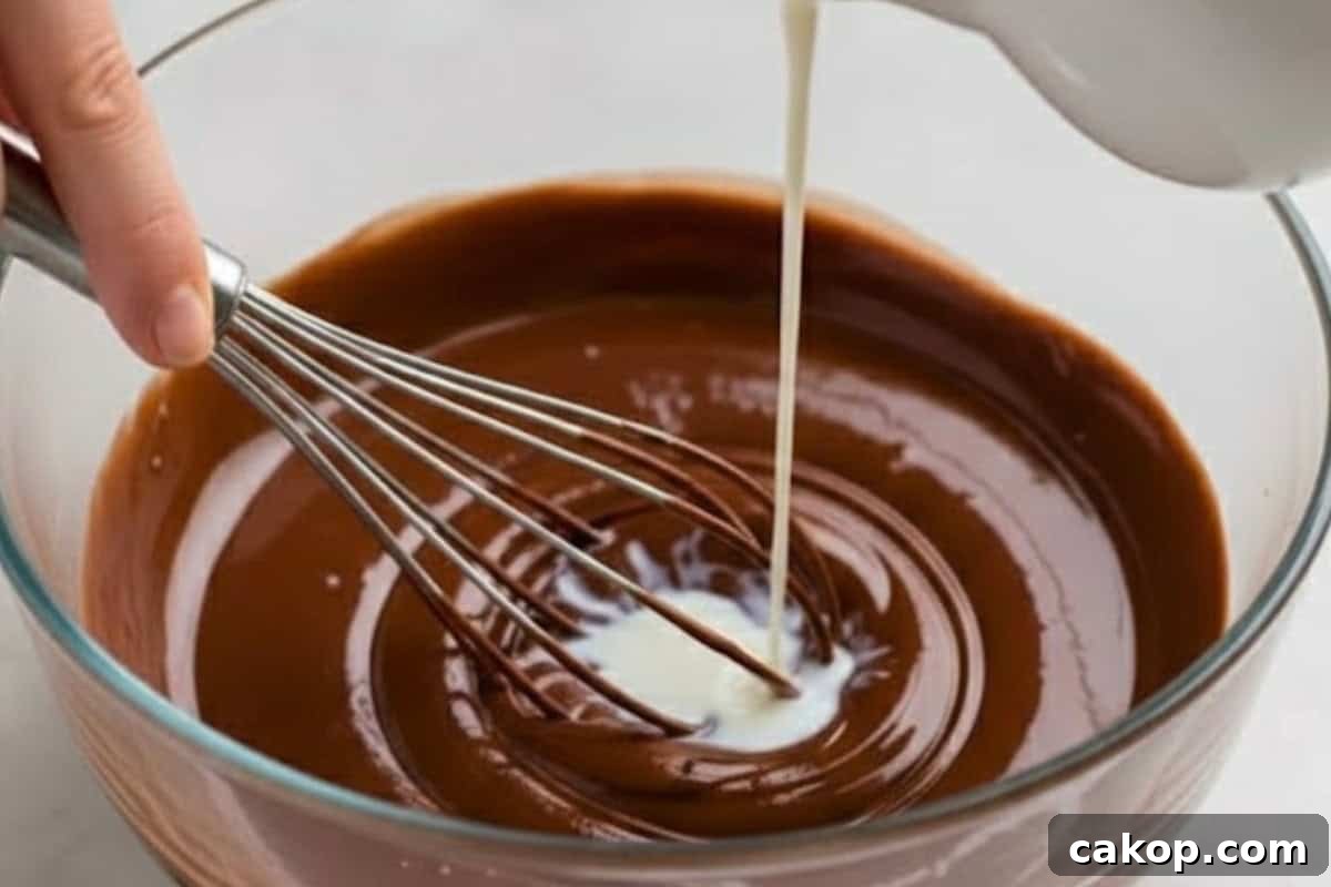 Slowly whisk in the milk until the chocolate loosens into a silky, pourable sauce.