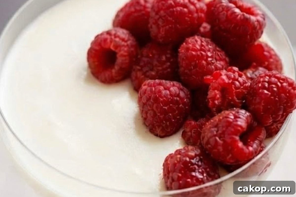 Add the remaining raspberries on top of each glass, letting a few settle naturally into the cream.