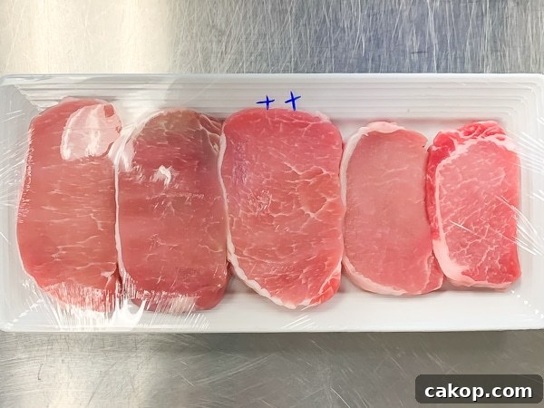 5 pork chops on a plate illustrating the visual differences.between them.