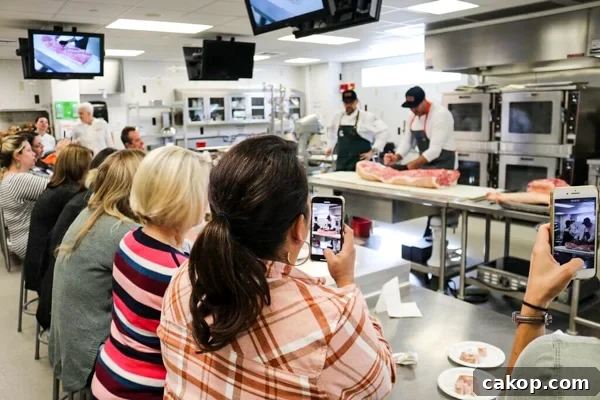 Bloggers learning about breaking down a half pig.