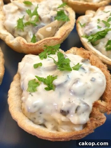 A plate of toasted mushroom breadcups garnished with chopped parsley.