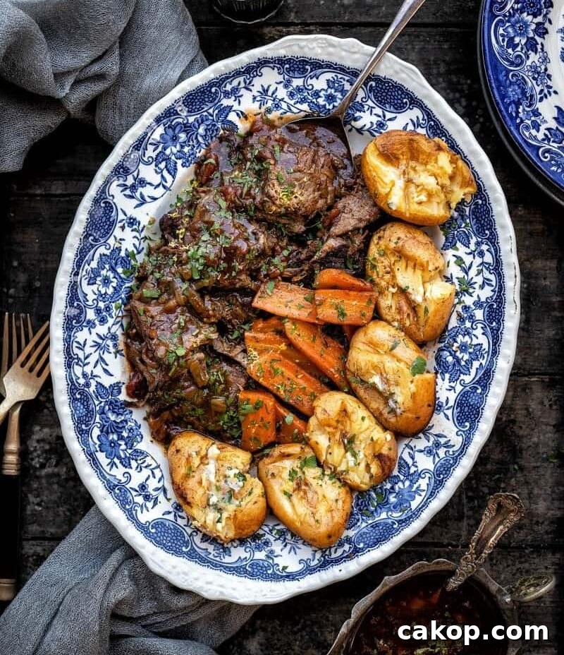 Instant Pot Beef Brisket with Garlic Smashed Potatoes 4 Sliced balsamic beef brisket arranged on a blue platter with potatoes and carrots