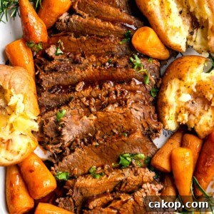 Instant Pot Beef Brisket with Garlic Smashed Potatoes 10 Close up on sliced brisket with vegetables on a platter.