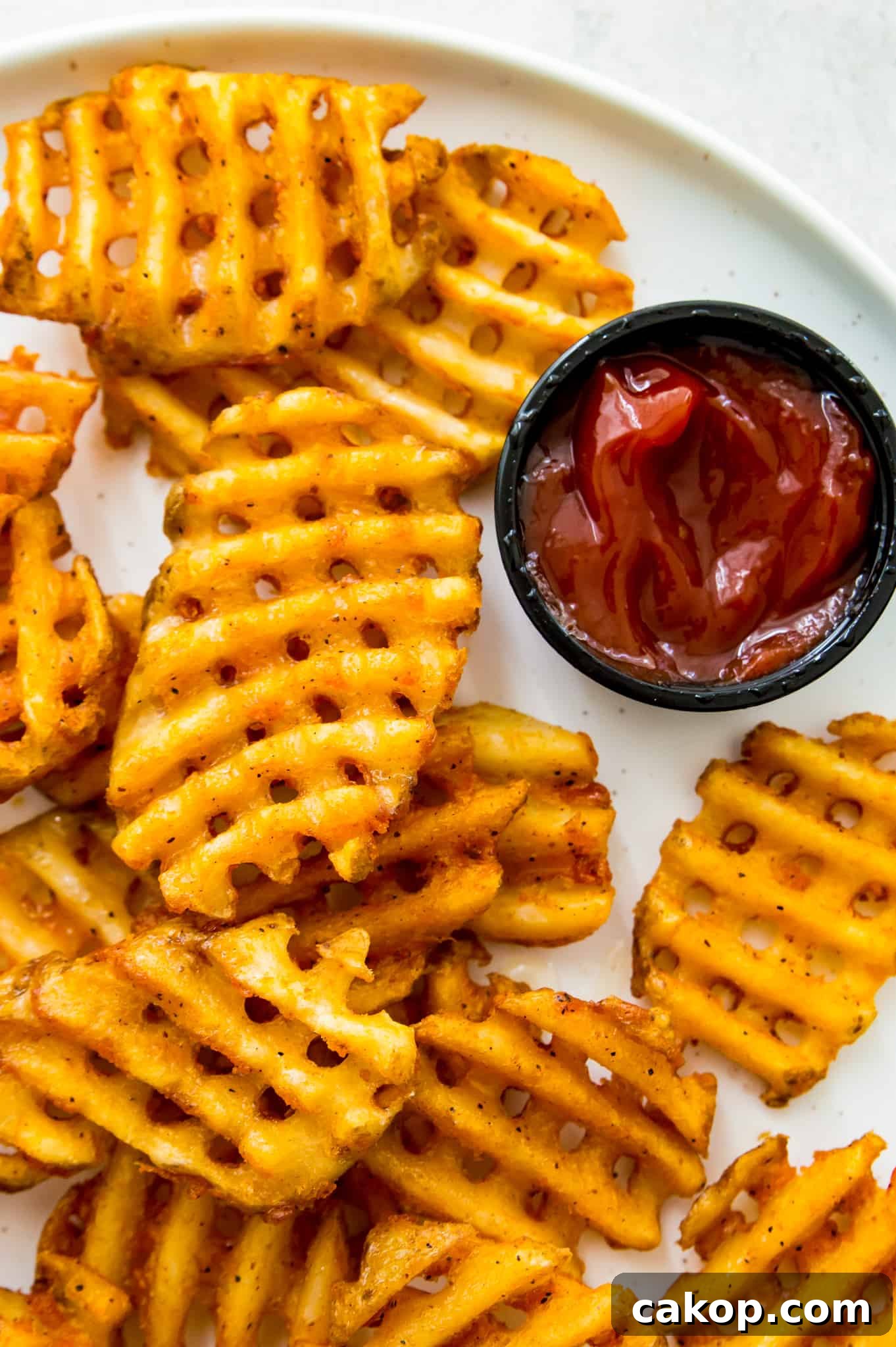 Frozen Waffle Fries in an Air Fryer A plate of waffles fries with a side of ketchup.
