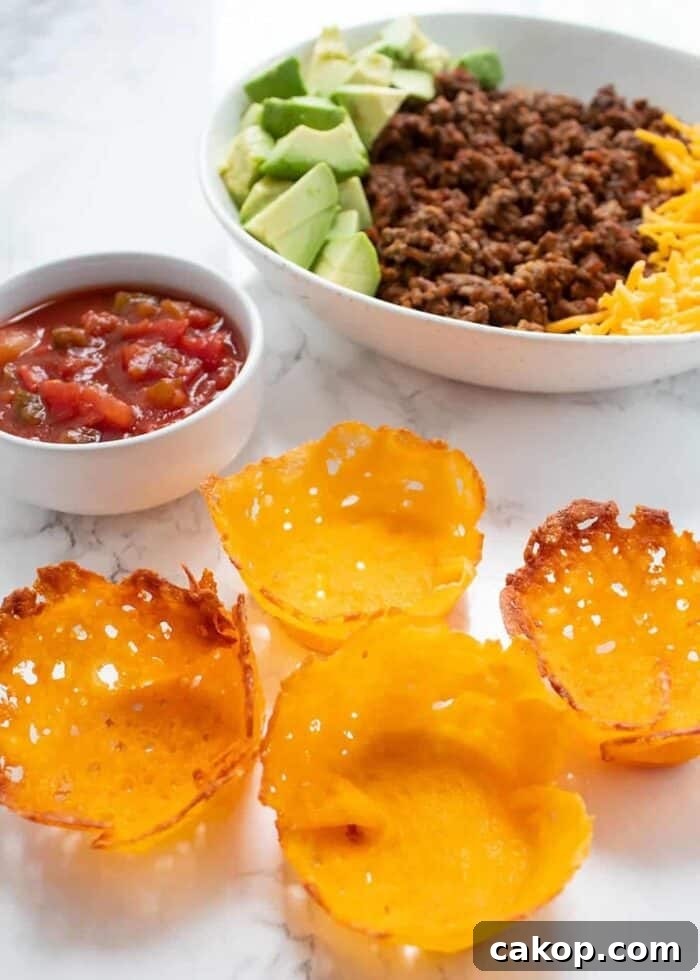 keto taco cups with salad and taco ingredients in background