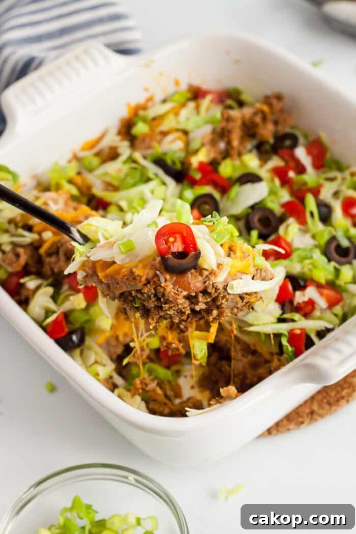 white casserole dish with spoon scooping out low carb taco casserole piece