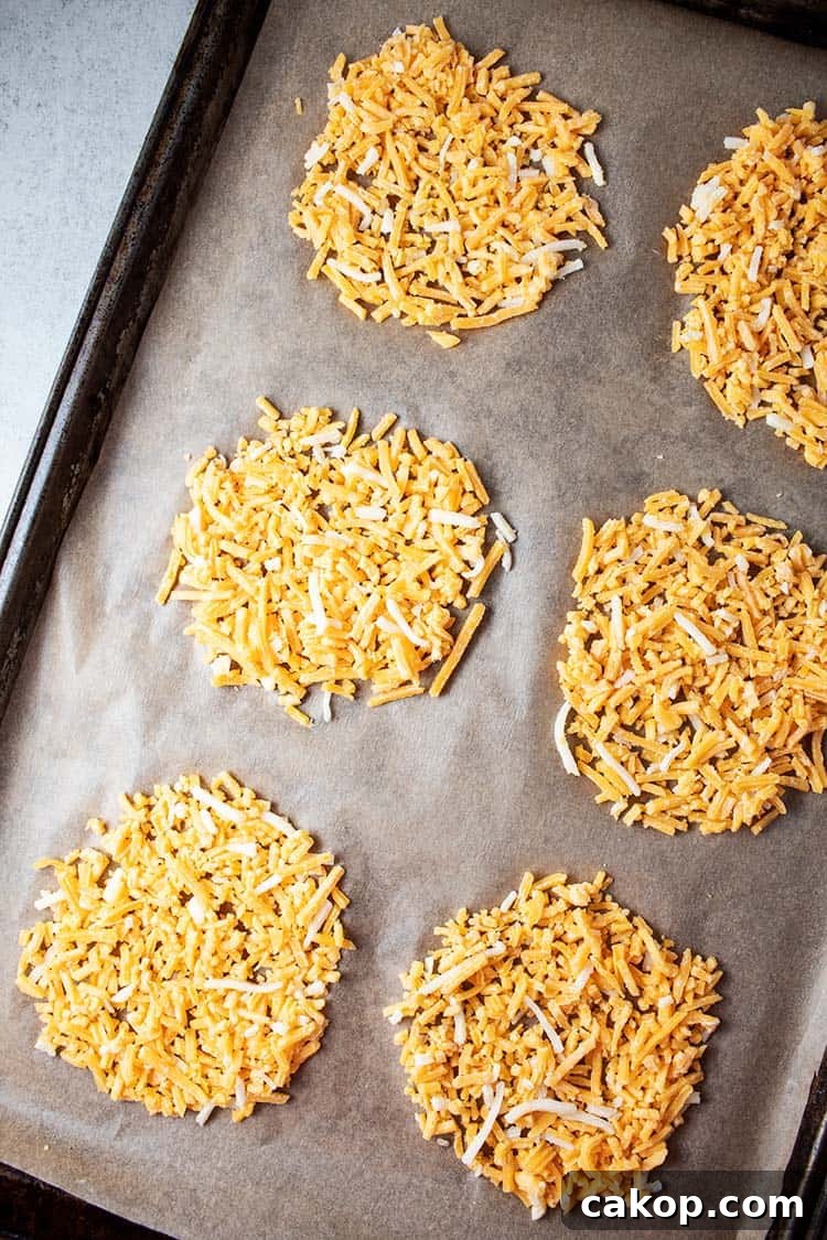 six piles of shredded cheese on a cookie sheet