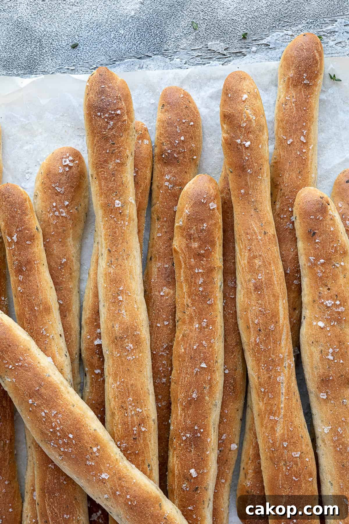 Close up of breadsticks on baking parchment. 