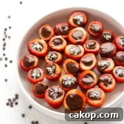 White bowl of chocolate coconut cream stuffed strawberries.
