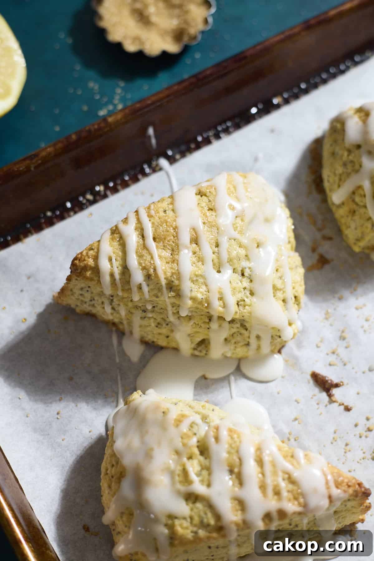 Sourdough Lemon Poppy Seed Scones Recipe for Tender, Tangy Bakes 12 Sourdough Lemon Poppy Seed Scones on white parchment paper.