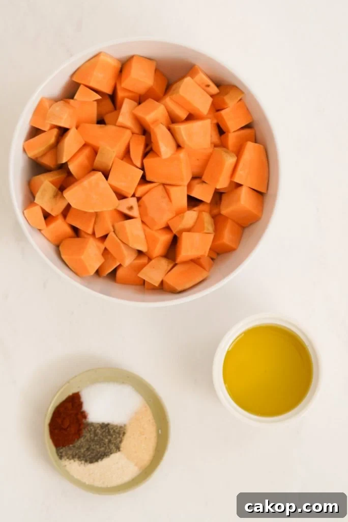sweet potato cubes, olive oil, and seasonings measured out on a white surface