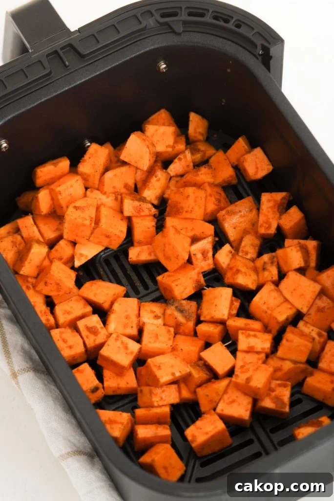 sweet potato chunks in an air fryer basket before cooking