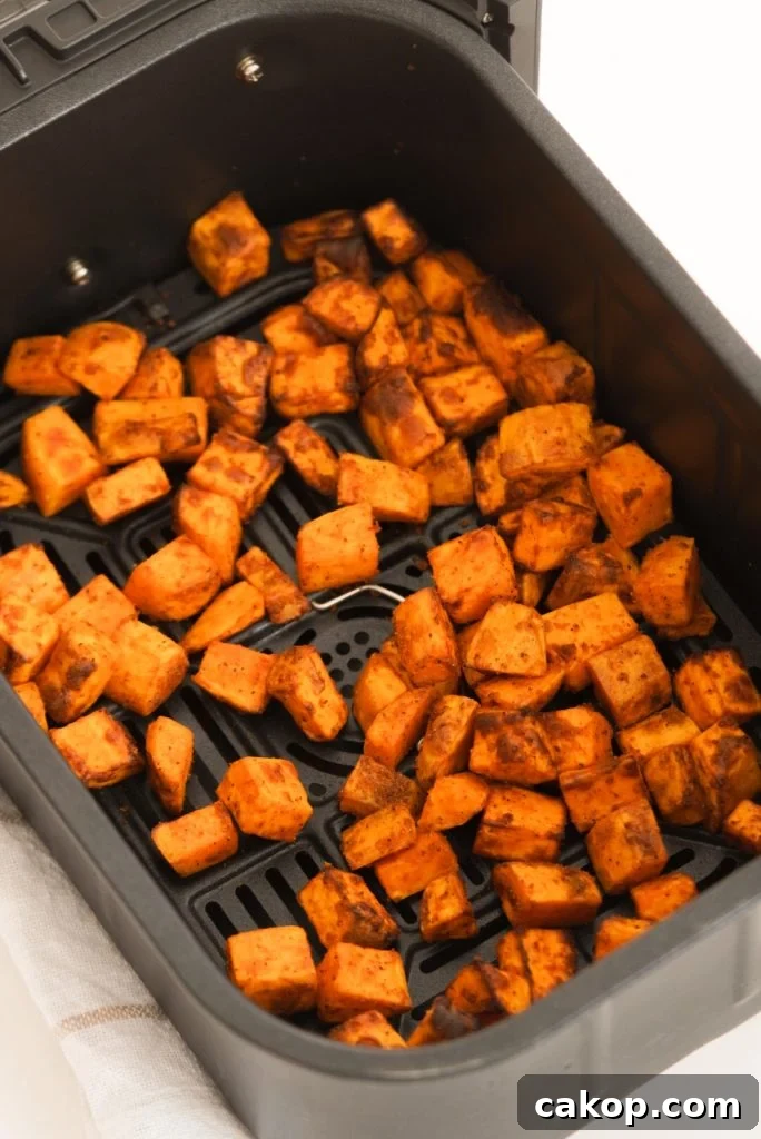 sweet potato chunks in an air fryer basket after cooking