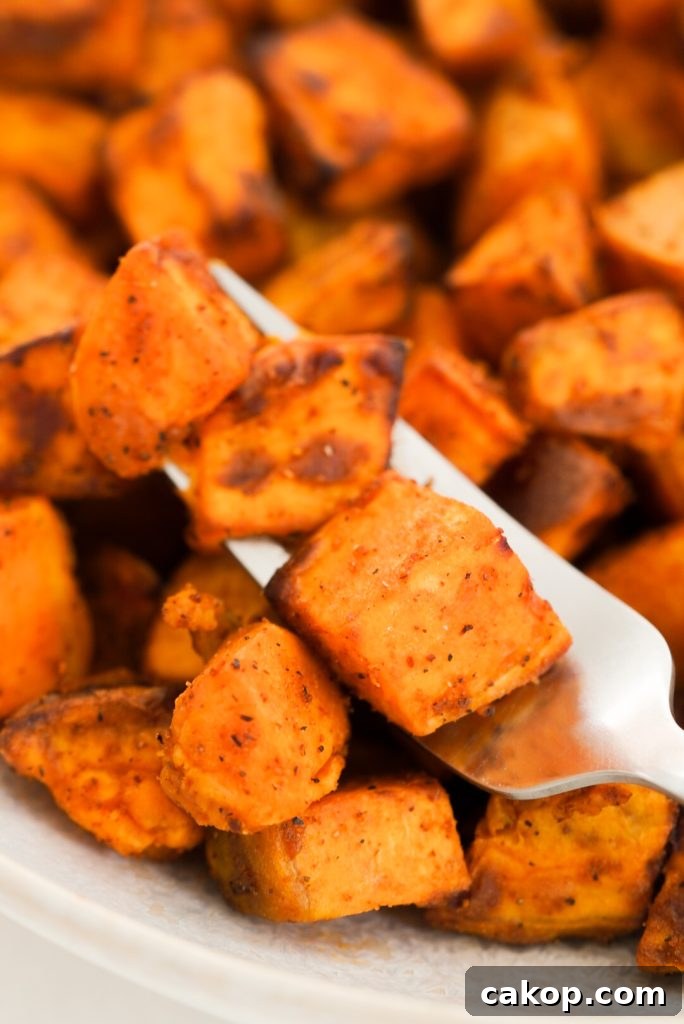 fork with three sweet potato cubes on it 