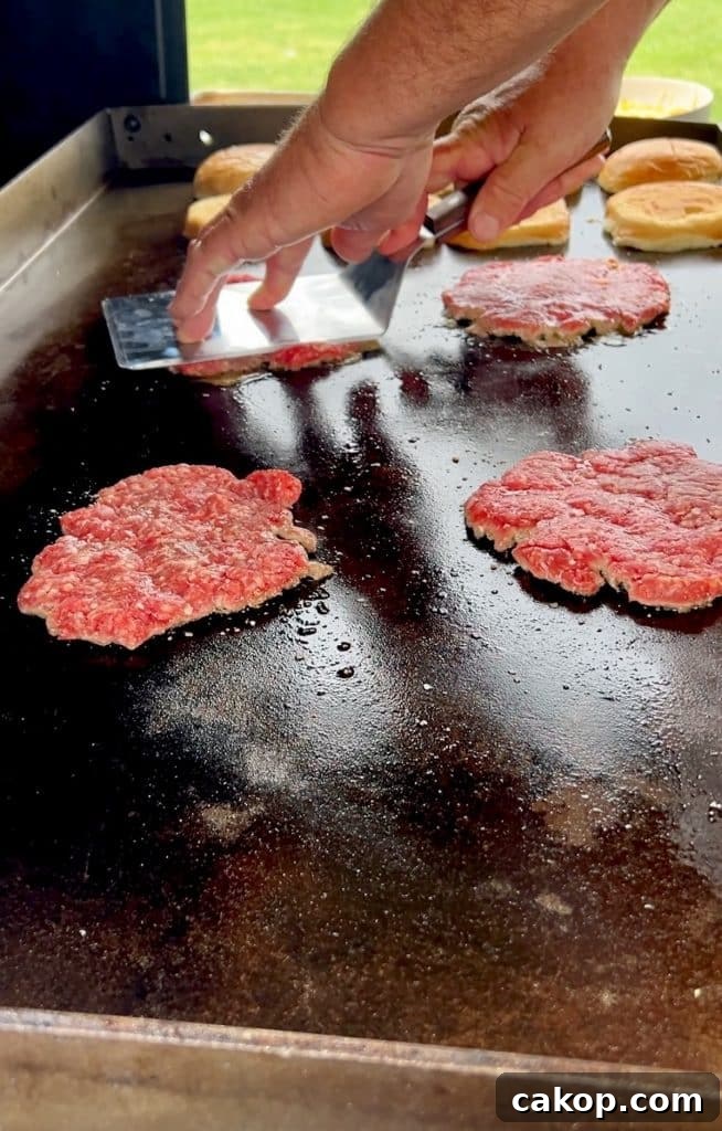 Guacamole Burger Recipe: Juicy Beef Patties with Fresh Avocado 3 Smashing burger patties on griddle.