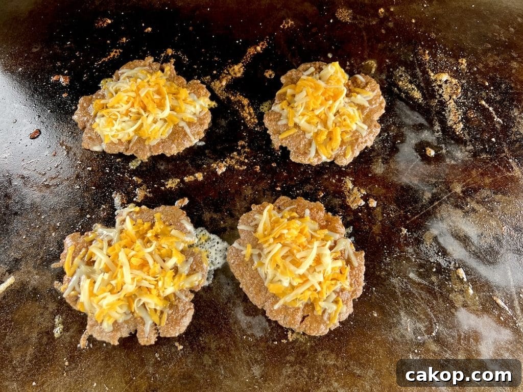 Guacamole Burger Recipe: Juicy Beef Patties with Fresh Avocado 5 4 cheeseburger patties on griddle.