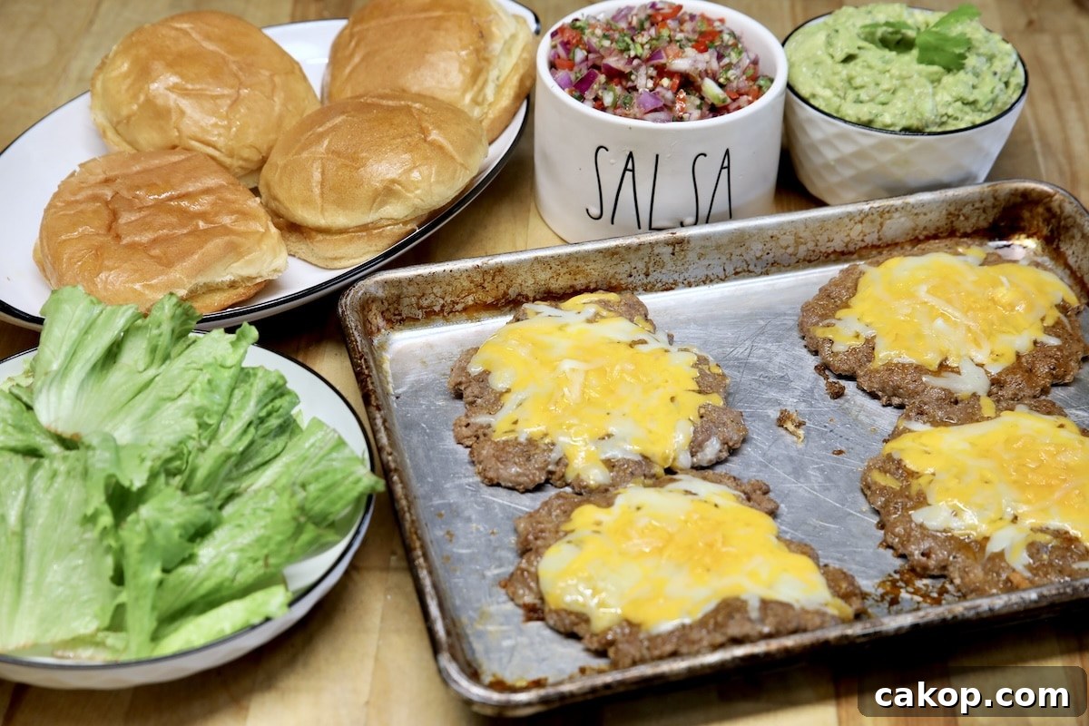 Burgers with guacamole and salsa. Burger patties on pan, lettuce, buns, guacamole, salsa.